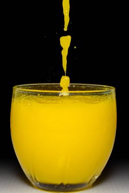 Cam ve siyah arka planda sıçrama sarı suya düşen su damlaları fotoğrafı