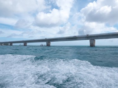 Okinawa, Japonya-20 Haziran 2020: Ikema köprüsü köprünün altından geçen bir tekneden izlendi