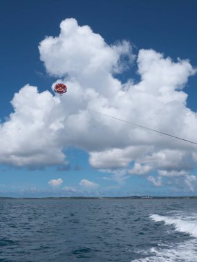 Okinawa, Japonya-20 Temmuz 2020: Miyakojima adasında mavi gökyüzü arka planında paraşütle atlama