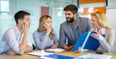 İş dünyası ekibi şirket toplantısında kadın yöneticiye iş fikrini sunuyor..