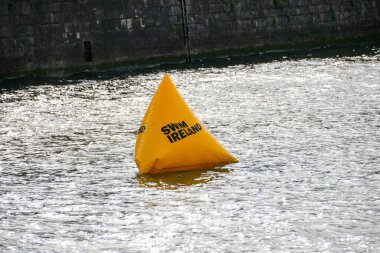 2025 Dublin, İrlanda 'da düzenlenen Yüzme İrlanda Liffey yüzme yarışması sırasında Liffey Nehri üzerinde yüzen İrlanda logosuna sahip şamandıra 2025-09-13.