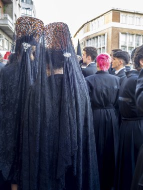 Leon, İspanya. 14 Nisan 2025. Kızıl saçlı genç, Leon, İspanya 'daki Paskalya geçit törenine katılmak için sokakta bekliyor..