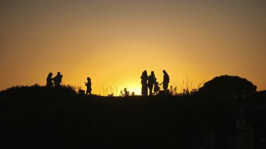 Marbella, İspanya. 2 Eylül 2025. Gün batımında Marbella, İspanya 'daki Artola Sahili tepelerinde bir grup insanın silueti..