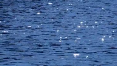 Güneş parlamayı su. Ufuk atışta güneş güzel bokeh dalgalı su yüzeyinin bakıyor
