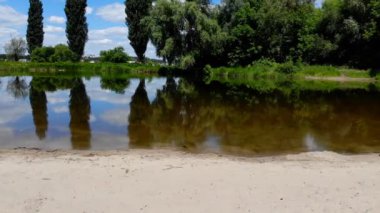 4k kamera sessiz bir göl sahil şeridi üzerinde uçuş. Gölet üzerinde helikopter pürüzsüz bir Asansör.