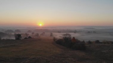 Hava görüntüsü. Sisin içinde uçmak, sisin içinde uçmak. Hava kamerası görüntüsü. Bulutların üzerinden güneşe doğru uç. Hava sisli, yukarıdan görünüyor. Kuşların bakış açısı