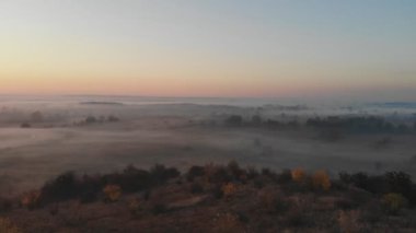 Hava görüntüsü. Sisin içinde uçmak, sisin içinde uçmak. Hava kamerası görüntüsü. Bulutların üzerinden güneşe doğru uç. Hava sisli, yukarıdan görünüyor. Kuşların bakış açısı