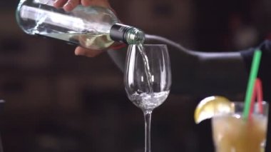 Barmen şık bir restoranda bir cam kadeh beyaz şarap dökme
