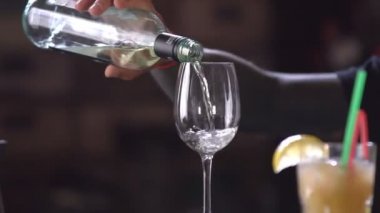 Barmen şık bir restoranda bir cam kadeh beyaz şarap dökme