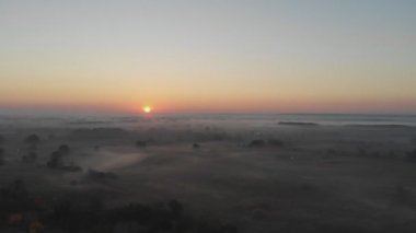 Hava görüntüsü. Sisin içinde uçmak, sisin içinde uçmak. Hava kamerası görüntüsü. Bulutların üzerinden güneşe doğru uç. Hava sisli, yukarıdan görünüyor. Kuşların bakış açısı
