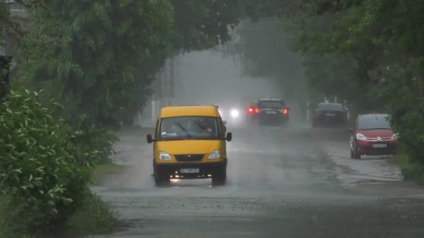 大雨淹没了街上 路上有小汽车和路过的人 — 图库视频影像