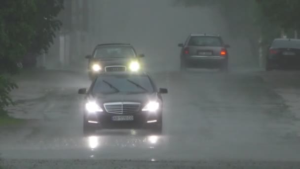 大雨淹没了街上 路上有小汽车和路过的人 — 图库视频影像