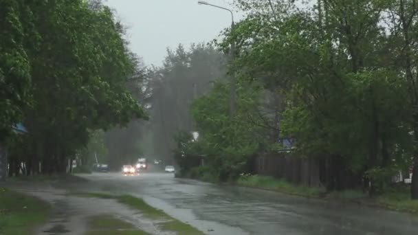 激しい春の雨は 道路上の車や通り過ぎる人々で通りを洪水 — ストック動画