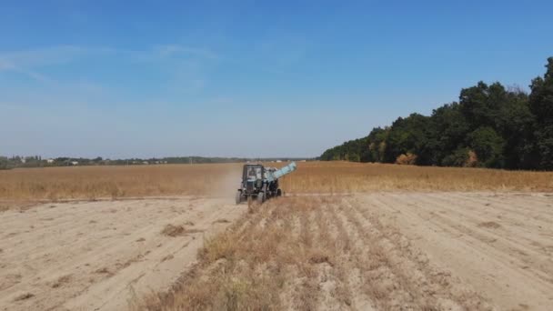 秋のホット晴れた日に地面とフィールド上の現代の強力なポテト収穫機フライトを追跡します — ストック動画
