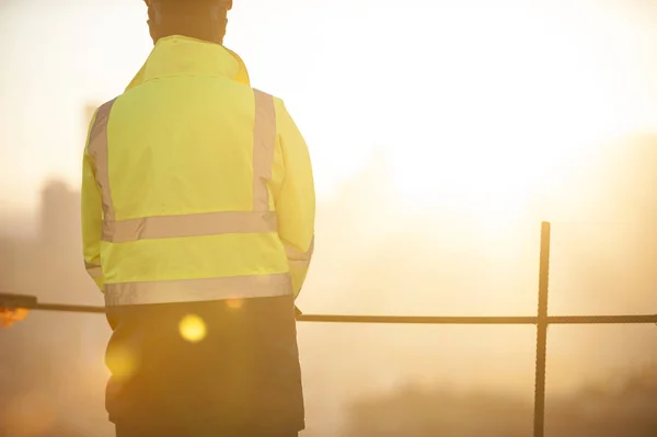 Worker at the construction site and sunrise background