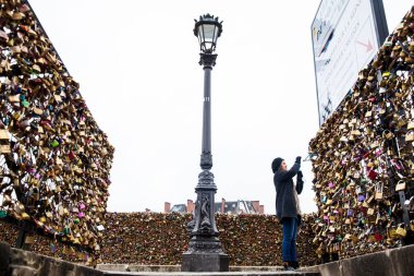 Paris, Fransa - Mart, 2018: Paris Pont Neuf adlı aşk kilitleri bir resim çekmek genç kadın
