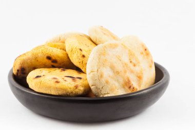 Kavrulmuş geleneksel Güney Amerika Mısır arepa beyaz arka plan üzerinde siyah bir seramik tabak