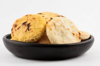 Kavrulmuş geleneksel Güney Amerika Mısır arepa beyaz arka plan üzerinde siyah bir seramik tabak