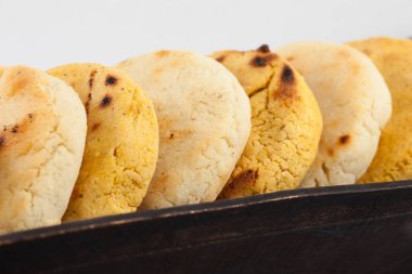 Kavrulmuş geleneksel Güney Amerika Mısır arepa beyaz arka plan üzerinde siyah bir seramik tabak