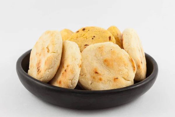 Kavrulmuş geleneksel Güney Amerika Mısır arepa beyaz arka plan üzerinde siyah bir seramik tabak