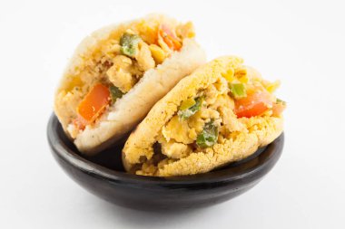 Omlet ve beyaz arka plan üzerinde siyah bir seramik tabak servis arepas dolu