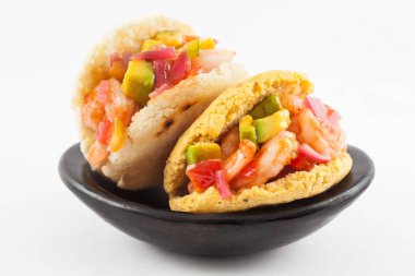 Karides meze beyaz arka plan üzerinde siyah bir seramik tabak servis arepas dolu