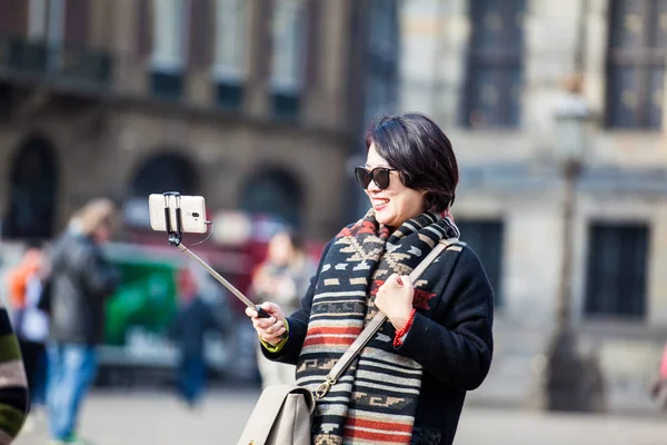 アムステルダム オランダ 2018 アジア観光客アムステルダムのダム広場の写真を撮るために携帯電話を使用して — ストック写真