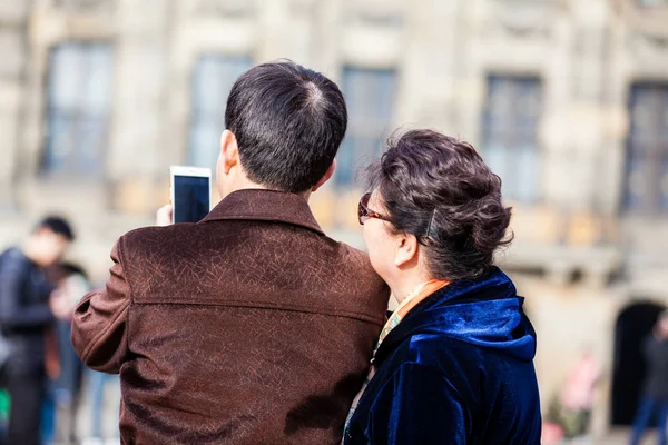 アムステルダム オランダ 2018 アジア観光客アムステルダムのダム広場の写真を撮るために携帯電話を使用して — ストック写真