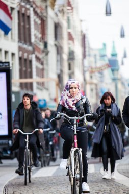 Amsterdam, Hollanda - Mart, 2018: Amsterdam eski Merkez ilçe, soğuk erken bahar günü bisikletçi