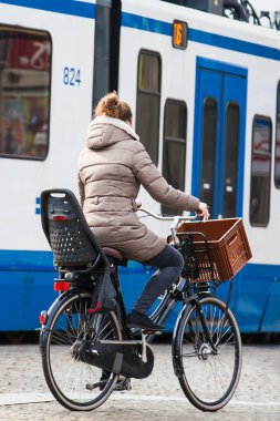 Amsterdam, Hollanda - Mart, 2018: Amsterdam eski Merkez ilçe, soğuk erken bahar günü bisikletçi