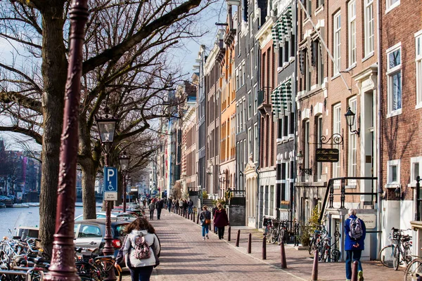 阿姆斯特丹 2018年3月 人们步行和骑自行车在美丽的鹅卵石街道旁边的运河的老中央区的阿姆斯特丹 — 图库照片