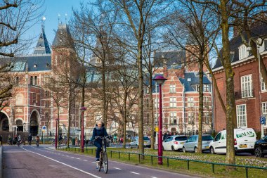 Amsterdam, Hollanda - Mart, 2018: Bikeway yanındaki bir soğuk erken bahar günü Ulusal Müzesi Amsterdam, bisikletçiler
