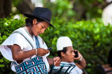 Cartagena De Indias, Kolombiya - Ağustos, 2018: İki Arhuaco erkekler Cartagena de Indias cep telefonlarını kullanarak kendi geleneksel kıyafetleri ile giyinmiş
