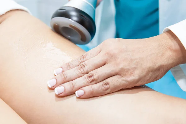 Lekarz wykonuje zabieg ultracavitation na młodych kobiet nogi pacjenta — Zdjęcie stockowe