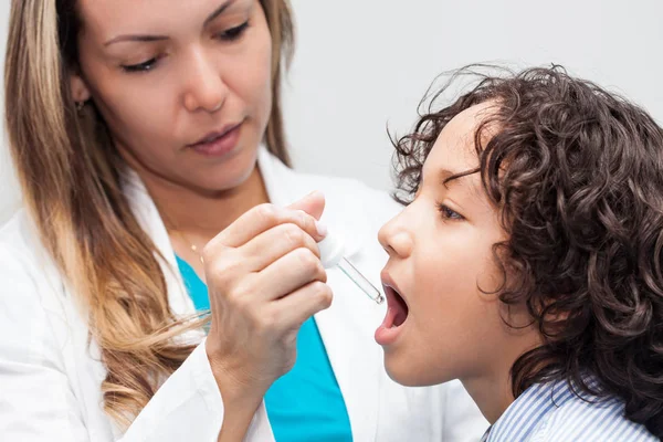 Doctor giving a child homeopathic medicine Royalty Free Stock Images