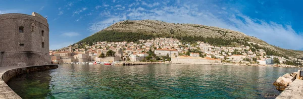 Mediterranean panorama of the beautiful Dubrovnik old city including the old port, city walls and fortifications — Stock Photo, Image