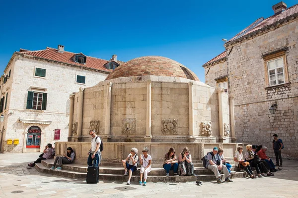 Turistas en la gran fuente de Onofrio situado en la calle Stradun en el casco antiguo de Dubrovnik — Foto de Stock