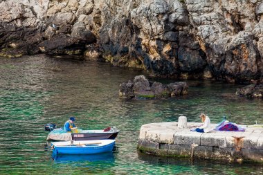 Dubrovnik Batı İskelesi'nde genç bir kadın ressam için poz balıkçı