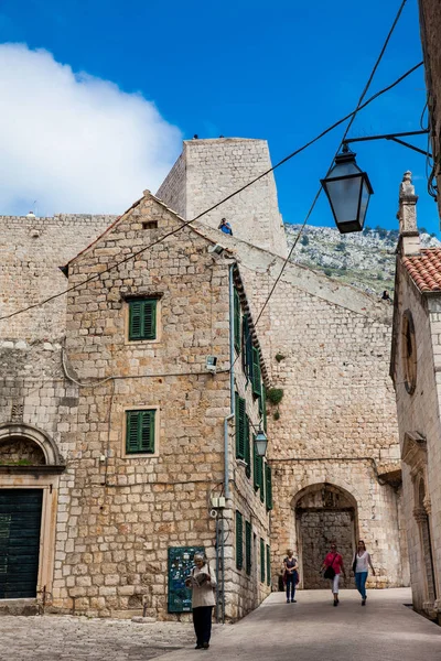Gente caminando por los hermosos callejones en el casco antiguo amurallado de Dubrovnik — Foto de Stock