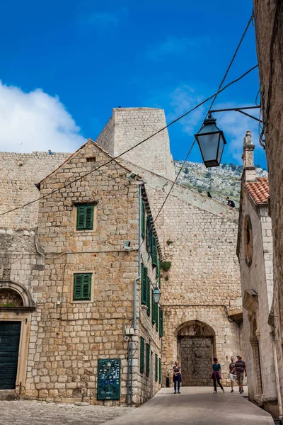 Gente caminando por los hermosos callejones en el casco antiguo amurallado de Dubrovnik — Foto de Stock