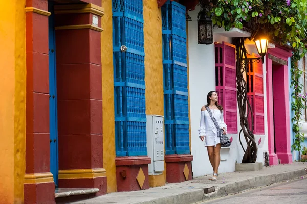 Hermosa mujer vestida de blanco caminando sola por las coloridas calles de la ciudad amurallada colonial de Cartagena de Indias —  Fotos de Stock