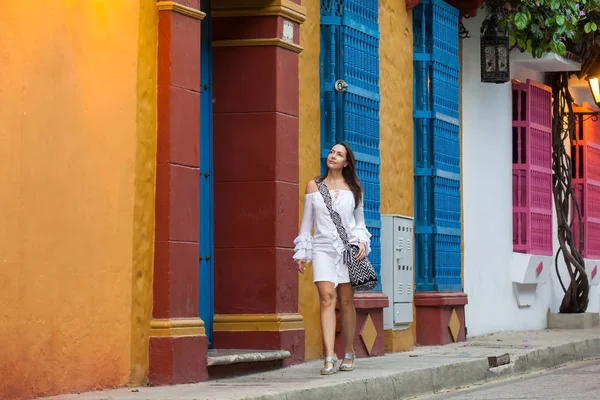 Mooie vrouw op witte jurk lopen alleen op de kleurrijke straten van de koloniale ommuurde stad van Cartagena de Indias — Stockfoto