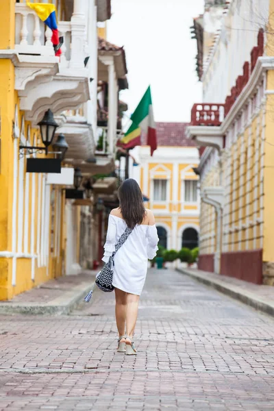 Beautiful woman on white dress walking alone at the streets of the colonial walled city of Cartagena de Indias — Stock Photo, Image