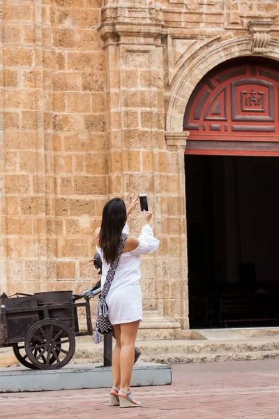 Hermosa mujer tomando fotos de la iglesia de San Pedro Claver ubicada en la ciudad amurallada de Cartagena de Indias — Foto de Stock