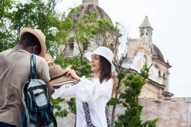 Cartagena de Indias bir sokak satıcısından geleneksel bir Kolombiyalı şapka satın güzel genç kadın