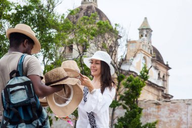 Cartagena de Indias bir sokak satıcısından geleneksel bir Kolombiyalı şapka satın güzel genç kadın