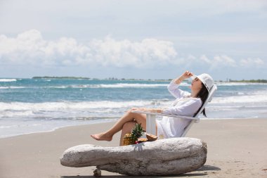 Paradisiac tropik bir plajda güneşli bir günde dinlenen bir kadın.