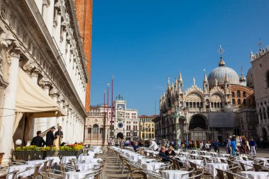 Güzel güneşli erken bahar gününde Venedik ünlü Saint Mark Meydanı'nda restoranlar ve turistler