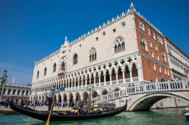 Venedik'teki Büyük Kanal'da Doge Sarayı'nın önünde bir gondolda yelken süren turistler