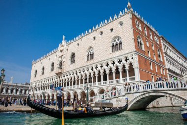 Venedik'teki Büyük Kanal'da Doge Sarayı'nın önünde bir gondolda yelken süren turistler